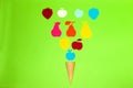 ice cream cone with various colorful paper fruits on a green background, creative art summer concept Royalty Free Stock Photo