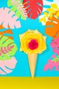 ice cream cone with yellow rose flower head on blue jungle leaves tropical background, creative summer design Royalty Free Stock Photo