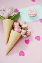 Ice cream cones with pink flowers and mint envelope on pink pastel background with heart shaped confetti Royalty Free Stock Photo