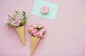 Ice cream cones with pink flowers and mint envelope on pink pastel background Royalty Free Stock Photo