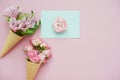 Ice cream cones with pink flowers and mint envelope on pink pastel background Royalty Free Stock Photo