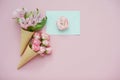 Ice cream cones with pink flowers and mint envelope on pink pastel background Royalty Free Stock Photo