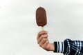 Ice cream covered with chocolate and almonds sticks in hand white background. Royalty Free Stock Photo