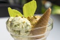 Ice cream cup decorated with with pieces of nuts. Pistachio ice cream cup on white table homemade with kitchen background Royalty Free Stock Photo