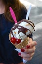 Hand with red nails hanging ice cream with chocolate cherries and two spoons