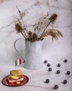 Ice cream filled cookies with over a flag of Italy and in the background a vase with dried flowers and blueberries Royalty Free Stock Photo