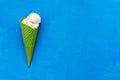 Ice cream in a green waffle cone on a blue background, flat lay. Top view, copy space. Summer refreshing dessert Royalty Free Stock Photo