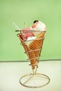 Ice Cream Holders. Strawberry, mint, vanilla with sour cherry ice cream in large waffle cone in holder, spoon. Royalty Free Stock Photo