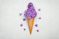 Ice cream of lilac flowers in waffle cone on gray background from above, beautiful floral arrangement, flat lay Royalty Free Stock Photo