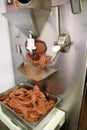 Ice cream making machine produces black chocolate ice cream flavors and it falls into steel container.