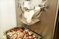 Ice cream making machine produces vanilla ice cream with chocolate dressing and it falls into steel container.