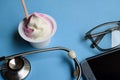 Ice cream medical concept. Stethoscope on doctor desk. Blue background Royalty Free Stock Photo