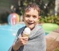 Ice cream is my favourite. Cropped portrait of an adorable little pool eating an ice cream while sitting outside by the