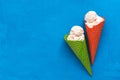 Ice cream in a red and green waffle cone on a blue background, flat lay. Top view, copy space. Summer refreshing dessert. Sundae Royalty Free Stock Photo