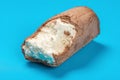 Ice cream roll with chocolate outer on blue with some bites