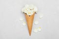 Ice cream of rose flowers in waffle cone on light gray background from above, beautiful floral decoration, vintage color, flat lay Royalty Free Stock Photo