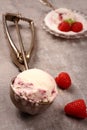 Ice cream scoop with berry ice cream and raspberry on old wooden background Royalty Free Stock Photo