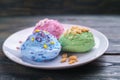 Ice cream scoops with nuts and sugar sprinkles on white plate. D