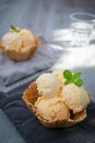 Ice cream scoops with vanilla ice cream in a bowl with mint. Vertical photo