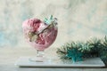 Ice cream served in a glass bowl. Displayed with candy canes on wooden rustic table. Sparkling Christmas tree lights background
