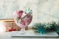 Ice cream served in a glass bowl. Displayed with candy canes on wooden rustic table. Sparkling Christmas tree lights background