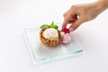 Ice cream served in a waffle bowl and female hand picking raspberry isolated on white background Royalty Free Stock Photo