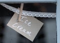 Ice cream sign pegged to lace in shop window