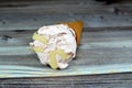 Ice-cream of special flavors in crispy wafer cones, melting cold ice cream twirl in a wafer biscuits isolated on wooden background