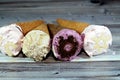Ice-cream of special flavors in crispy wafer cones, melting cold ice cream twirl in a wafer biscuits isolated on wooden background