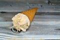 Ice-cream of special flavors in crispy wafer cones, melting cold ice cream twirl in a wafer biscuits on wooden background