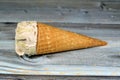 Ice-cream of special flavors in crispy wafer cones, melting cold ice cream twirl in a wafer biscuits on wooden background