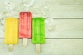 Ice cream stick with cube ices on a wooden background.