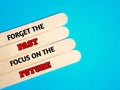 Ice cream stick with text Forget the past and focus on the future on the blue background.