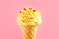 Ice cream. Vanilla, banana or lemon flavor icecream in waffle cone over pink background