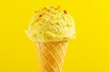 Ice cream. Vanilla, banana or lemon flavor icecream in waffle cone over yellow background