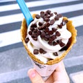 Ice cream vanilla chips flavor frozen dessert pattern in waffle cone hand holding