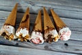 Ice cream vanilla and chocolate cones with topping of chocolate and caramel sauce and nuts in a crispy wafer cones, melting cold