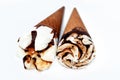 Ice cream vanilla cones with topping of chocolate and caramel sauce and nuts in a crispy wafer cones, selective focus of melting Royalty Free Stock Photo