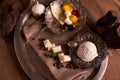 Ice cream in a vintage ice-cream bowl on a vintage metal tray with an assortment of cheeses, blackberries on a wooden table.
