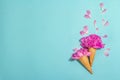 Ice cream waffle cones with peony on blue background. Flower petals, summer concept. Romantic style Royalty Free Stock Photo