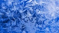 Ice crystals close-up on a window glass in winter. Dark blue and white background or wallpaper. Mystical fabulous abstract pattern Royalty Free Stock Photo