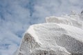 Ice crystals formed on rockface in winter against cloud sky Royalty Free Stock Photo