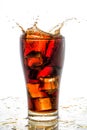 Ice cube droped in cola glass and cola splashing Royalty Free Stock Photo