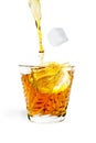 Ice cube with lemon drops from splashes into the glass with alcohol Royalty Free Stock Photo