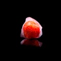 Ice cube and strawberry isolated on a black background