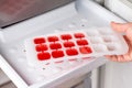 Ice cube tray with frozen wine in the freezer