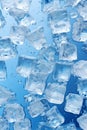 Ice cubes on blue glass background, pattern of crystal frozen icecubes