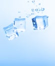 Ice cubes in blue water create bubbles that float to the surface Royalty Free Stock Photo