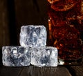 Ice cubes, cola on a dark wooden background
