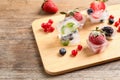 Ice cubes with different berries and mint on table Royalty Free Stock Photo